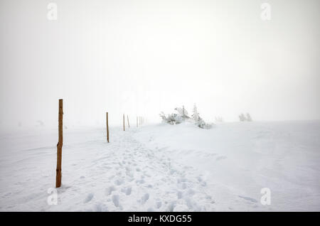 Scarpe da escursionismo impronte nella neve, Blizzard in monti Karkonosze, paesaggio invernale, Polonia. Foto Stock