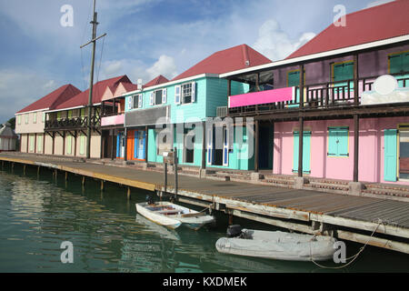 Il porto con le sue case colorate lungo il bordo dell'acqua, San Giovanni, Antigua, dei Caraibi. Foto Stock
