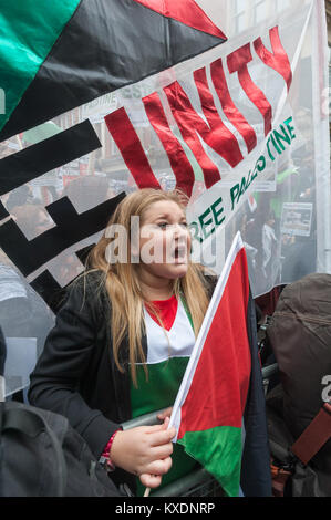 Una donna con una bandiera palestinese sorge nella parte anteriore di sinistra unità banner in segno di protesta contro l'ambasciata Israeliana a Londra per chiedere la fine della colonizzazione israeliana e di repressione e di libertà per la Palestina. Foto Stock