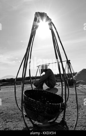 Stanco di un lavoratore di sesso femminile che la raccolta del sale di stagni di acqua vicino DocLet, Vietnam. Iniziano a lavorare a lungo prima di sunrise, al fine di evitare la maggior parte del calore Foto Stock