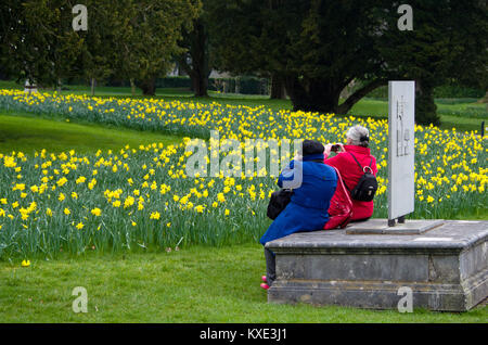 Due anziani signori, a contrastare il rosso e il blu cappotti, fotografare fiori di primavera a Trentham Gardens; Stoke on Trent, Staffordshire Foto Stock