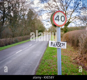 Un residente locale annuncio Si prega?! Per un segnale di limite di velocità di 40 km/h fuori del West Sussex città di Midhurst. Foto Stock