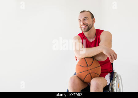 Atleta in carrozzina tenendo la pallacanestro Foto Stock