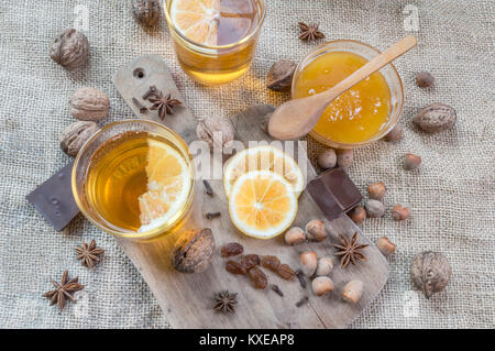 Anice stellato, arancione frut affettato, cannella, un vasetto di miele, dadi e chiodi di garofano su un tavolo di legno. Vista superiore piatta o laici. Messa a fuoco selettiva. Foto Stock