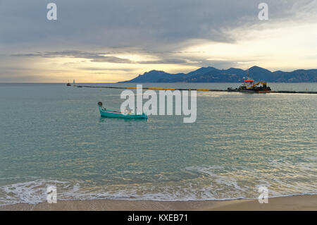 La pesca tradizionale barca noto come pointu lavora con reti da pesca nella baia di Cannes in inverno. Esterel all'orizzonte Foto Stock