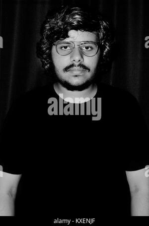 Ritratto di giovane Uomo con occhiali su sfondo nero. Foto Stock