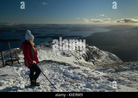 Giovane ragazza e il Cairn Terrier nella neve sopra Loch Lomond Scozia, Regno Unito. Foto Stock