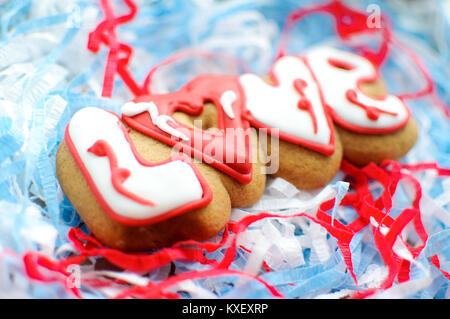 Lettera i cookie per il giorno di San Valentino o per un giorno di nozze su blu e del libro bianco sullo sfondo di riempimento. Vista dall'alto, il fuoco selettivo, copia dello spazio. Foto Stock