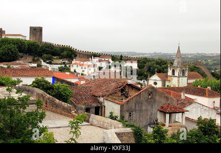 Obidos, Portogallo. Splendido piccolo le strade di ciottoli, pareti e tetti su diversi livelli. Foto Stock