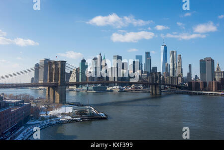 Il Ponte di Brooklyn e lo skyline di Lower Manhattan come visto In inverno dal lato di Brooklyn attraverso l'East River Foto Stock