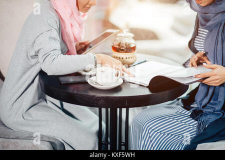 Musulmani donna business documenti di lavoro in cafe Foto Stock