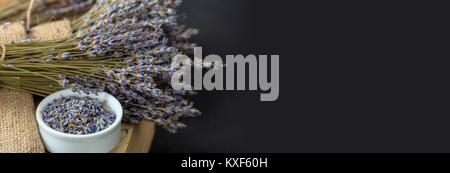 Lavanda essiccata mazzetto e ciotola bianco su sfondo nero Foto Stock