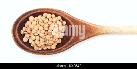 Materie lenticchie in un cucchiaio di legno su sfondo bianco Foto Stock