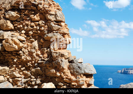 Vista del blu del mare e del cielo dal foro nella vecchia stonewall parete. Viaggi turismo. Foto Stock