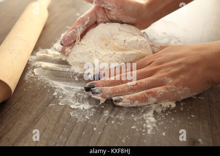 Donna mani impastare close-up. La cucina è casalinga sfondo. Foto Stock