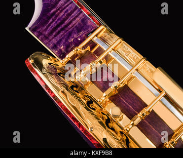 5-string banjo su sfondo nero. Legno intagliato Benjo collo. Intagliato dipinto. Insolito colore viola di legno., archtop tonering Foto Stock