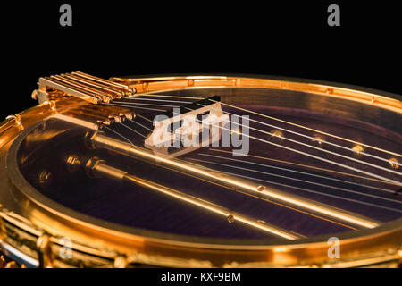 5-string banjo su sfondo nero. Legno intagliato Benjo collo. Intagliato dipinto. Insolito colore viola di legno., archtop tonering Foto Stock