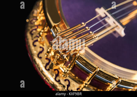 5-string banjo su sfondo nero. Legno intagliato Benjo collo. Intagliato dipinto. Insolito colore viola di legno., archtop tonering Foto Stock