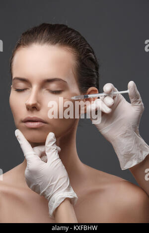 Ritratto di giovane donna ottenere iniezione di cosmetici. Pulire la bellezza. Foto Stock