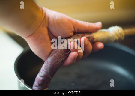 Chiusura del processo per la fabbricazione di salsiccia casalinga a casa con la macchina di pressione Foto Stock