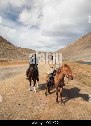 Il mongolo cavalieri appoggiato accanto al fiume montagna Mongolia inverno Foto Stock