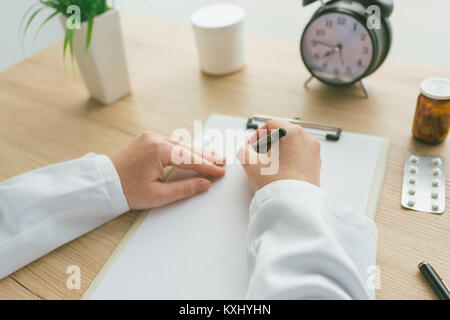 Medico donna scrivere le note mediche del paziente o di storia della medicina prescrizione sulla carta per appunti durante esame medico in ospedale office Foto Stock