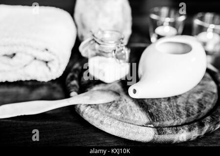 Neti pot, ayurvedico strumenti per la pulizia del naso con acqua e con acqua e sale, vista dall'alto, tavolo in legno e la scheda sullo sfondo Foto Stock