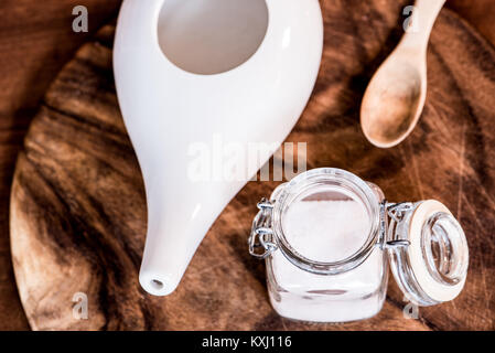 Neti pot, ayurvedico strumenti per la pulizia del naso con acqua e con acqua e sale, vista dall'alto, tavolo in legno e la scheda sullo sfondo Foto Stock