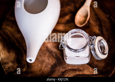 Neti pot, ayurvedico strumenti per la pulizia del naso con acqua e con acqua e sale, vista dall'alto, tavolo in legno e la scheda sullo sfondo Foto Stock