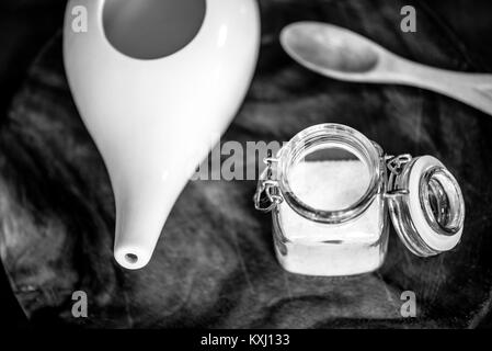 Neti pot, ayurvedico strumenti per la pulizia del naso con acqua e con acqua e sale, vista dall'alto, tavolo in legno e la scheda sullo sfondo Foto Stock