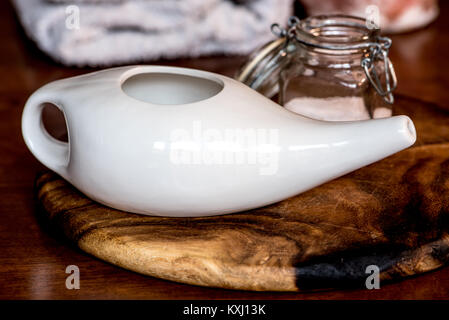 Neti pot, ayurvedico strumenti per la pulizia del naso con acqua e con acqua e sale, su di un tavolo di legno Foto Stock