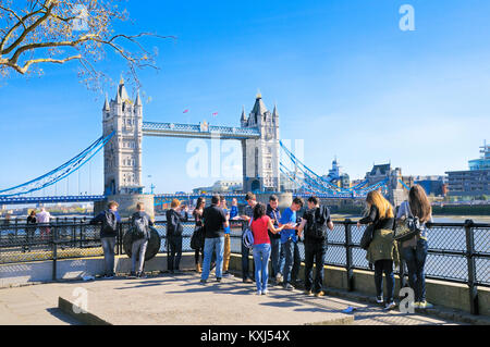 Un gruppo di adolescenti in giro per la capitale. Vista verso il Tower Bridge di Londra, Inghilterra, Regno Unito Foto Stock