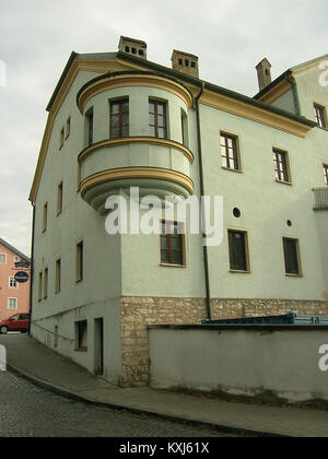Questa fotografia mostra l'edificio situato in Am Graben 21 a Eichstätt, Baviera, Germania, che cattura la sua facciata, il posizionamento urbano e i dettagli architettonici coerenti con le case a schiera dell'Europa centrale dei primi del XX secolo. Foto Stock