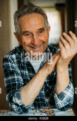 Ritratto di un anziano senior uomo seduto e sorridente Foto Stock