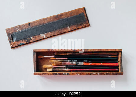 Direttamente sopra lo scatto di pennelli in cassa di legno su sfondo bianco Foto Stock