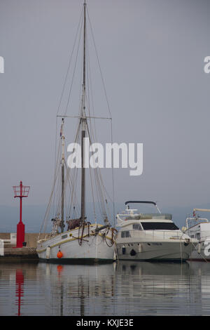 Vecchia barca a vela barca in legno (convertito da un vecchio Scandinavian barca da pesca) parcheggiata dalla moderna barca sull'isola di Krk in Croazia Foto Stock