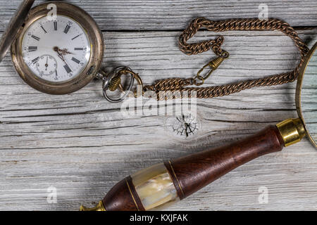 Argento Vintage orologio da tasca e lente di ingrandimento sul tavolo di legno Foto Stock