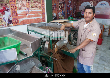 OAXACA, Messico - 6 marzo 2012: lavoratore in un cioccolato e mole shop La Soledad imballaggio le fave di cacao sacchi a Oaxaca, Messico Foto Stock