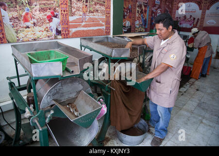 OAXACA, Messico - 6 marzo 2012: lavoratore in un cioccolato e mole shop La Soledad imballaggio le fave di cacao sacchi a Oaxaca, Messico Foto Stock