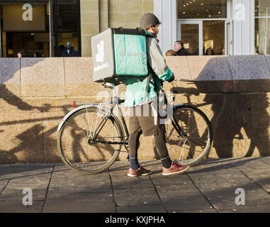 Un Deliveroo Consegna del cibo rider con ciclo a Newcastle upon Tyne, Regno Unito Foto Stock