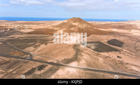 Vista aerea di strade che attraversano il paesaggio del deserto, panorama di montagne vulcaniche, coste di Fuerteventura, Isole Canarie, Spagna . Foto Stock