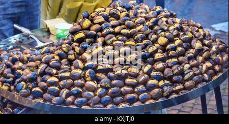 Piastra di metallo di grandi dimensioni con castagne arrostite in vendita in Piazza Navona il giorno dell Epifania Foto Stock