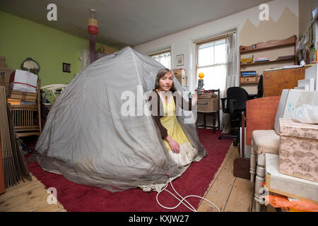 La donna che soffre di ipersensibilità elettromagnetica intolleranza sindrome (EHS) posti all'interno di una gabbia di Faraday a casa, London, Regno Unito Foto Stock