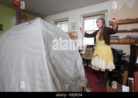 La donna che soffre di ipersensibilità elettromagnetica intolleranza sindrome (EHS) tenendo la guarigione Diapason e dorme all'interno di una gabbia di Faraday, REGNO UNITO Foto Stock