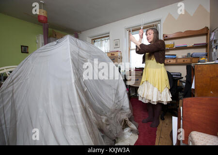 La donna che soffre di ipersensibilità elettromagnetica intolleranza sindrome (EHS) tenendo la guarigione Diapason e dorme all'interno di una gabbia di Faraday, REGNO UNITO Foto Stock