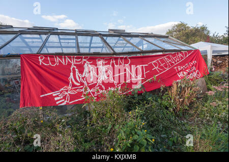 Un grande striscione su una delle serre a crescere Heathrow legge 'i baccelli non piste'. Foto Stock