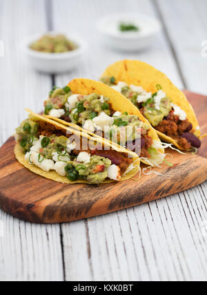 Le carni bovine macinate tacos su legno su sfondo grigio Foto Stock