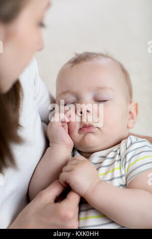 Madre lulling suo Figlio bambino a casa Foto Stock