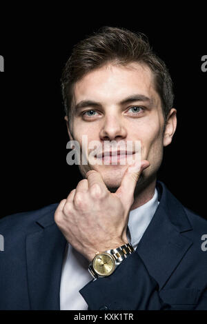 Ritratto di fiducioso uomo vestito da indossare su sfondo nero Foto Stock