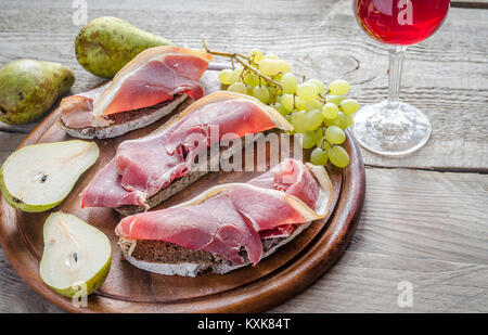 Panini con prosciutto italiano sulla tavola di legno Foto Stock